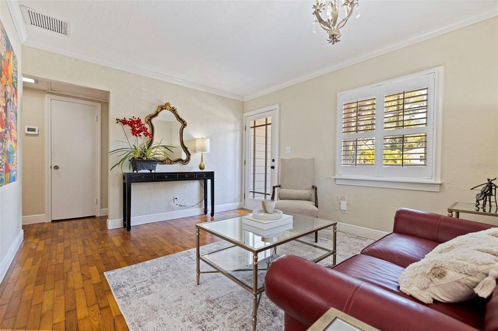 A living room features a red leather sofa, glass coffee table, and hardwood flooring — 1010 43RD AVENUE N, ST PETERSBURG, FL