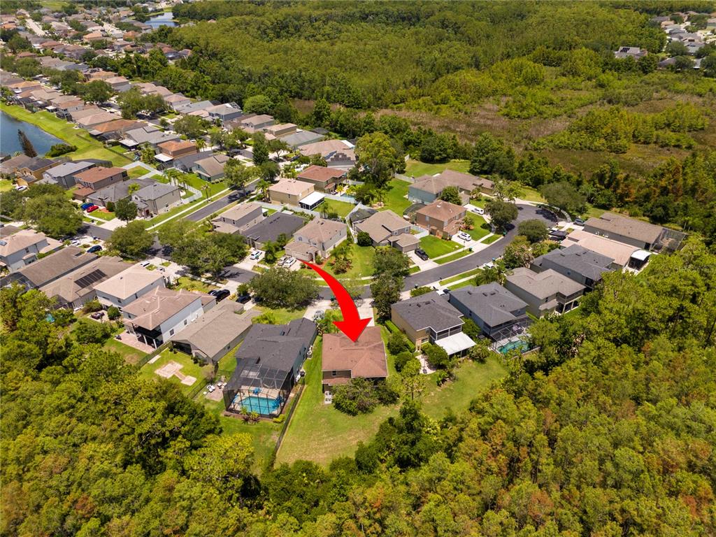 An aerial view shows a suburban neighborhood with a red arrow pointing to a house — 14938 HARTFORD RUN DRIVE, ORLANDO, FL
