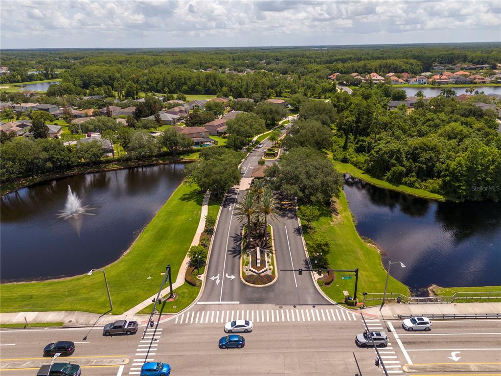An aerial view shows a gated community entrance with a fountain and surrounding ponds — 14938 HARTFORD RUN DRIVE, ORLANDO, FL
