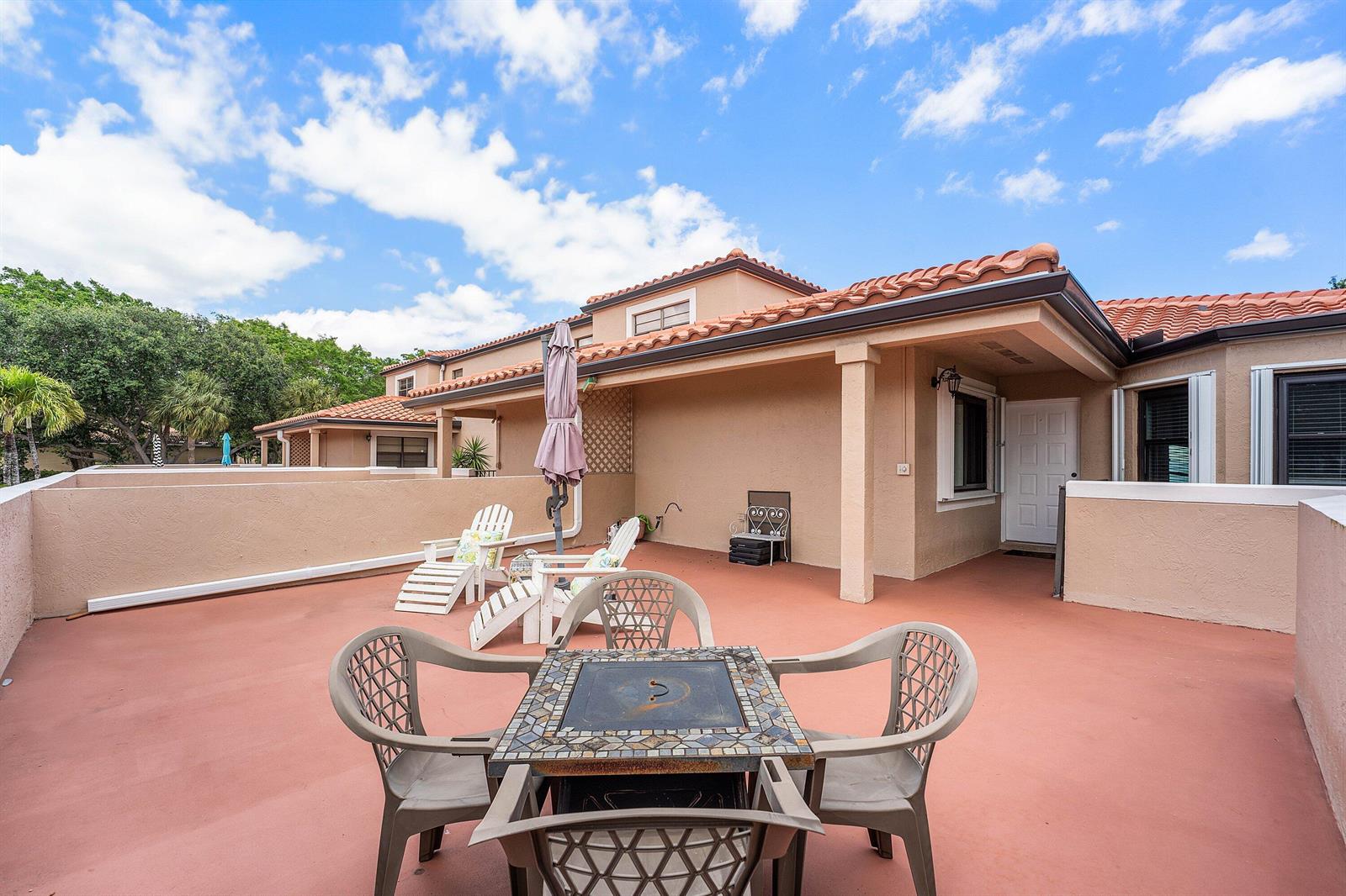 A spacious outdoor patio features a dining set, lounge chairs, and a covered porch area — 6614 Villa Sonrisa Drive # 123, Boca Raton FL 33433, BOCA RATON, FL