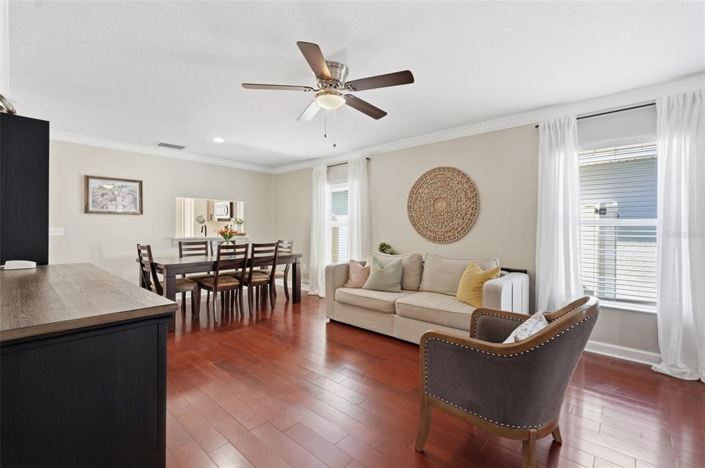 A living and dining area features hardwood floors, a ceiling fan, and neutral furniture — 7323 LUMBER PORT DRIVE, RUSKIN, FL