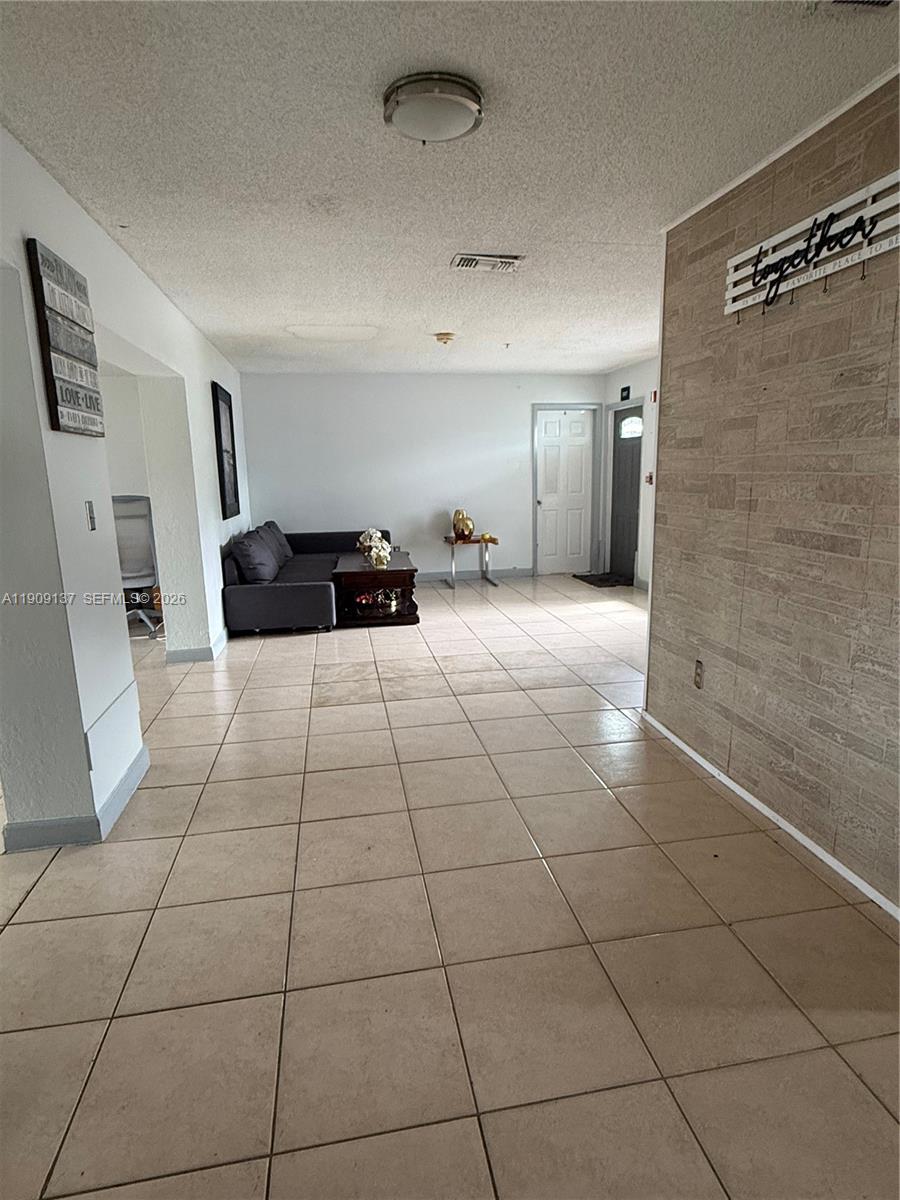 An open-concept living area features tiled floors, a dining space, and an adjacent kitchen — 17902 NW 81st Ct, Hialeah FL 33015, HIALEAH, FL