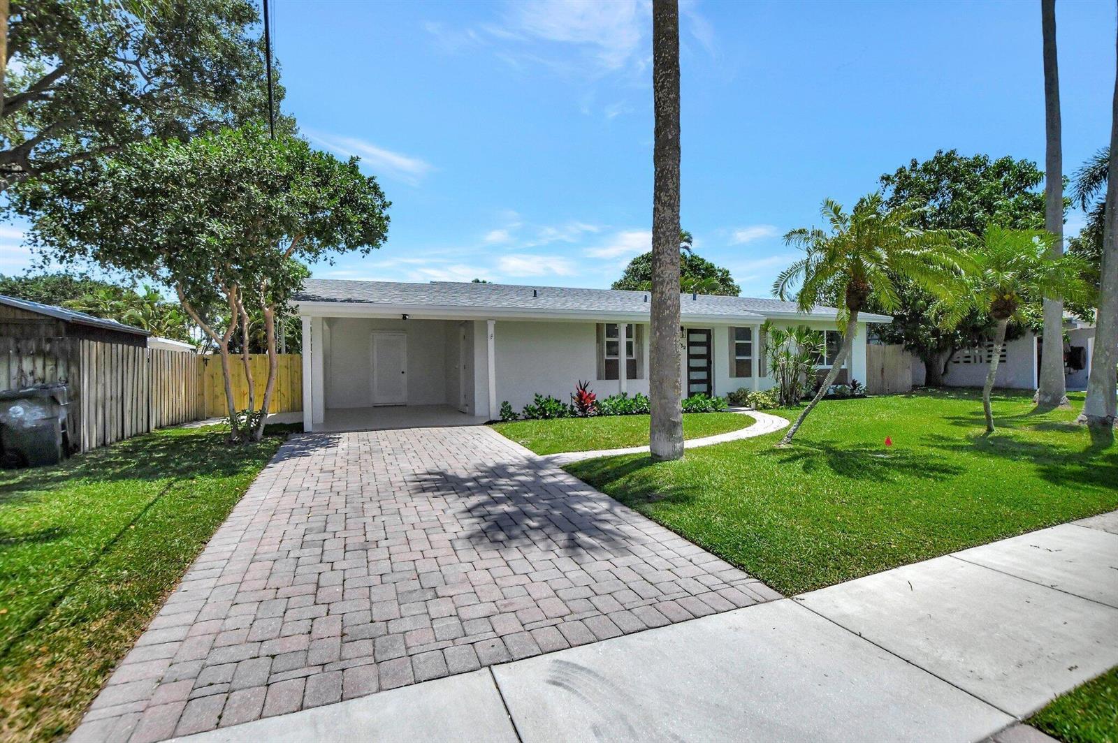 A single-story white house features a paved driveway, a carport, and a landscaped front yard — 832 SW 10th Avenue, Boca Raton FL 33486, BOCA RATON, FL