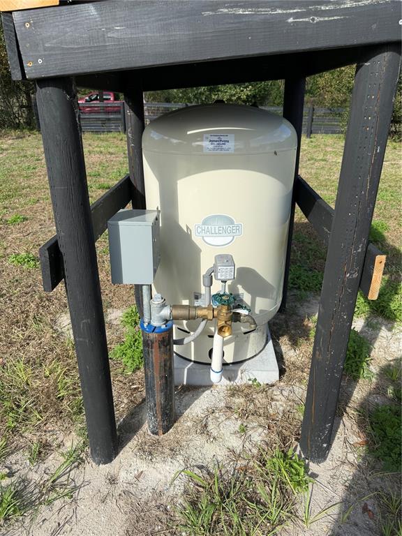 A well pump and pressure tank are housed under a wooden structure outdoors — 1043 HAZEN ROAD, DELAND, FL