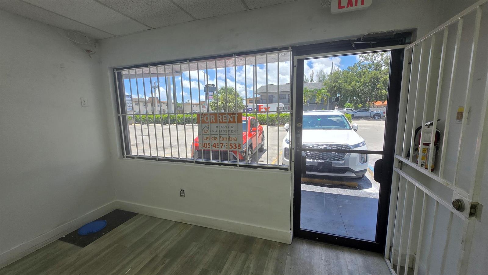 An empty commercial space features a large window with security bars and a glass door — 3300 E 4th Avenue # 5, Hialeah FL 33013, HIALEAH, FL