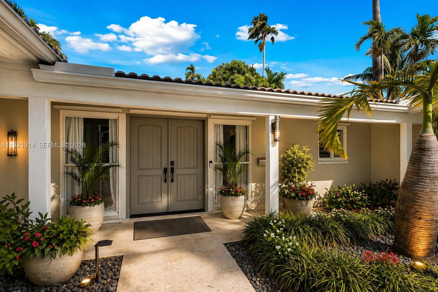 A backyard features a swimming pool, a covered patio, lounge chairs, and palm trees — 461 NE 115th St, Miami FL 33161, MIAMI, FL