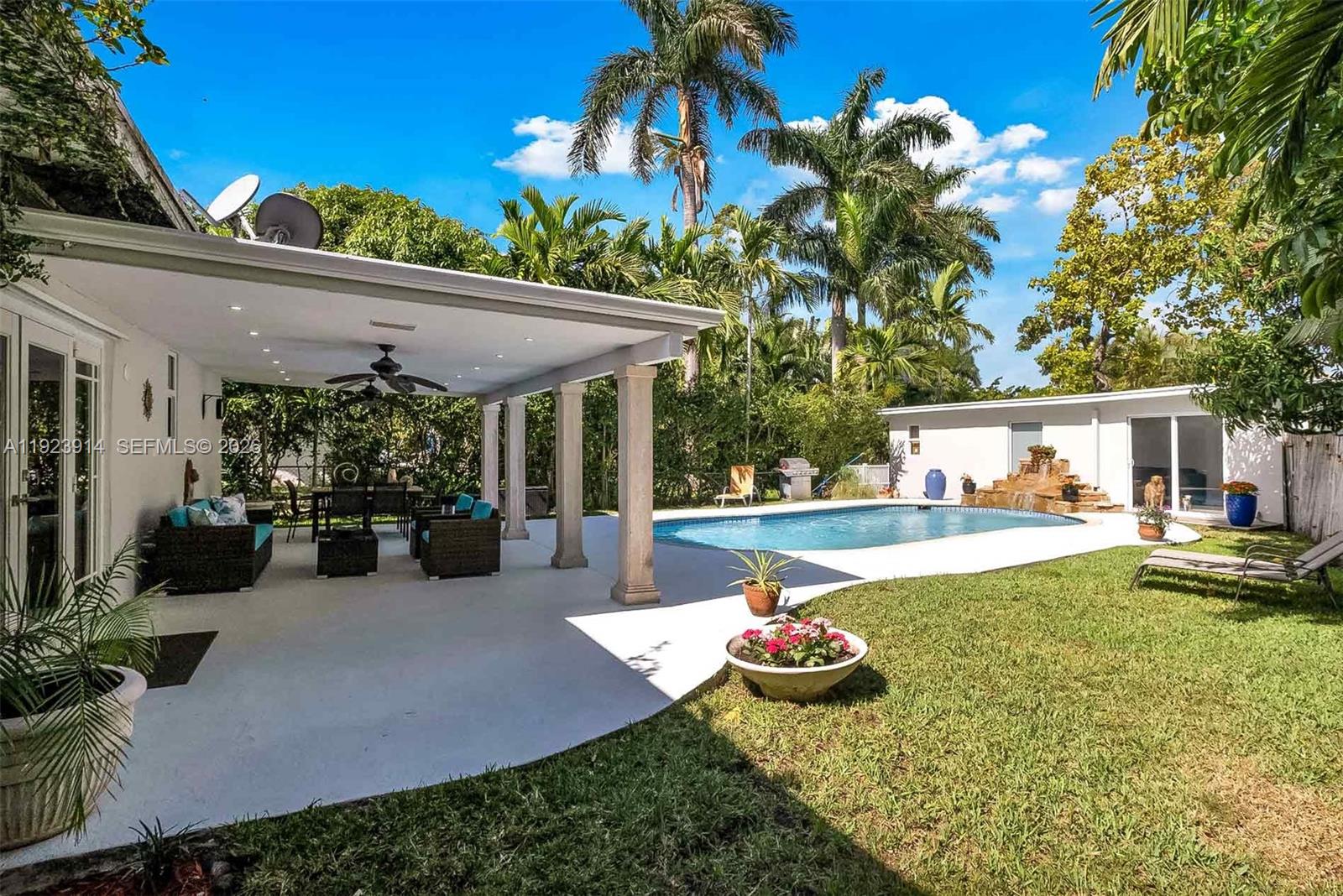 A single-story house with a white garage and palm trees at sunset — 461 NE 115th St, Miami FL 33161, MIAMI, FL