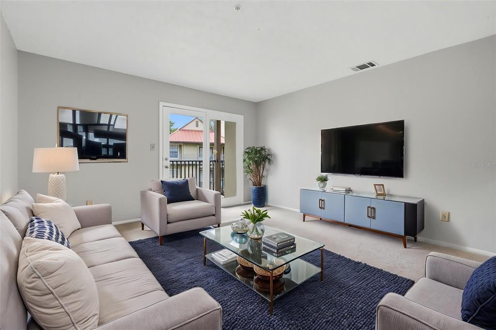 A living room features a sofa, two armchairs, a glass coffee table, and a television — 249 AFTON SQUARE UNIT 208, ALTAMONTE SPRINGS, FL