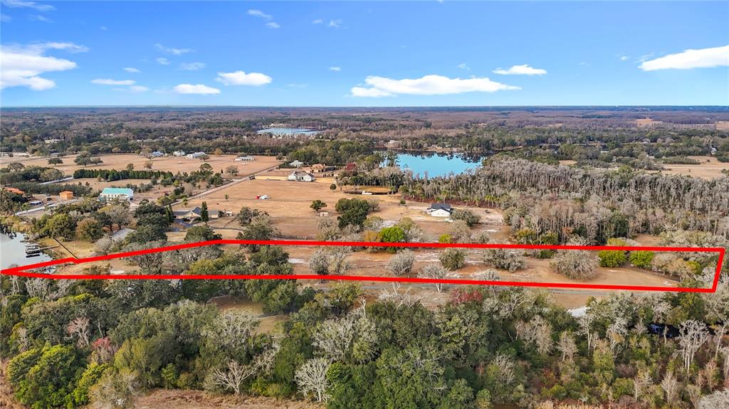 An aerial view shows a large, rectangular plot of land outlined in red — 8804 MISTY MORNING TRAIL, ODESSA, FL