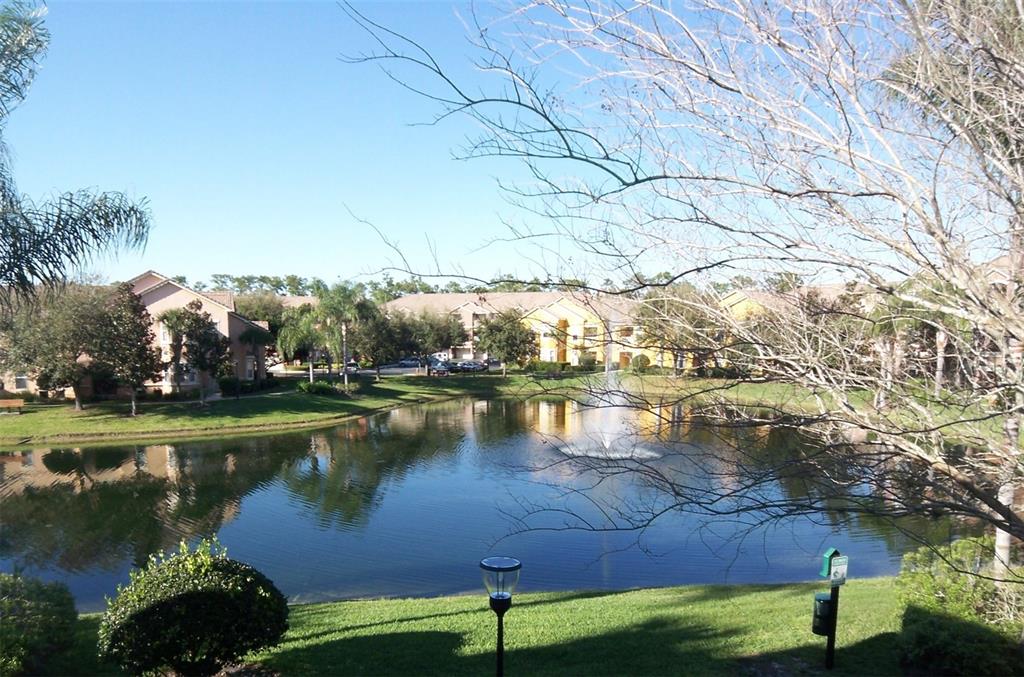 A view of a pond with a fountain surrounded by apartment buildings and trees — 8801 VILLA VIEW CIRCLE UNIT 206, ORLANDO, FL