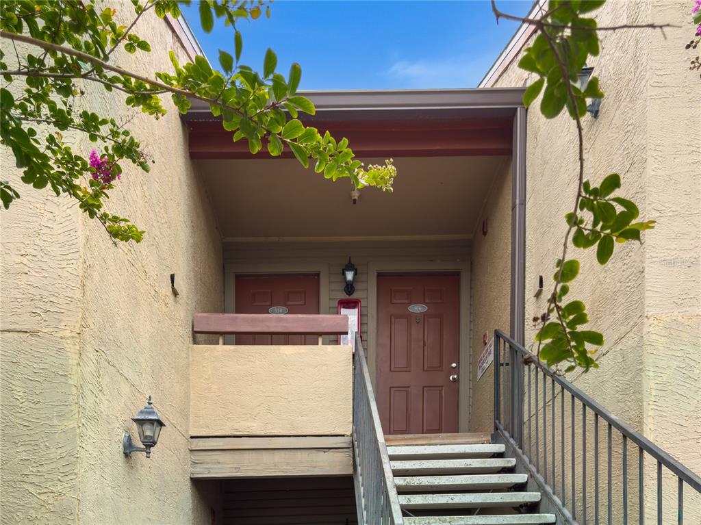 An exterior view shows a staircase leading to two apartment doors under a covered landing — 10265 GANDY BOULEVARD N UNIT 914, ST PETERSBURG, FL