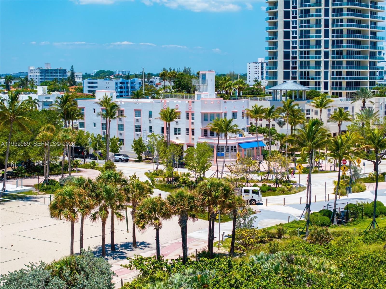 An exterior view of a white Art Deco building surrounded by palm trees and landscaping — 7300 Ocean Ter, Miami Beach FL 33141, MIAMI BEACH, FL