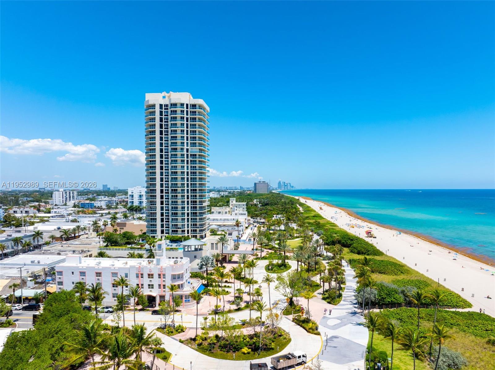An aerial view shows a tall residential tower, a beach, and surrounding palm trees — 7300 Ocean Ter, Miami Beach FL 33141, MIAMI BEACH, FL