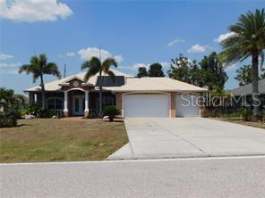 A single-story house with a two-car garage, palm trees, and a light-colored roof — 25352 DOREDO DRIVE, PUNTA GORDA, FL