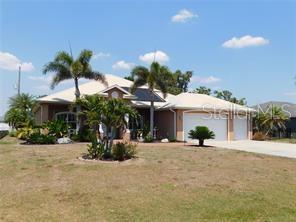 A single-story house with a light-colored roof, palm trees, and a two-car garage — 25352 DOREDO DRIVE, PUNTA GORDA, FL