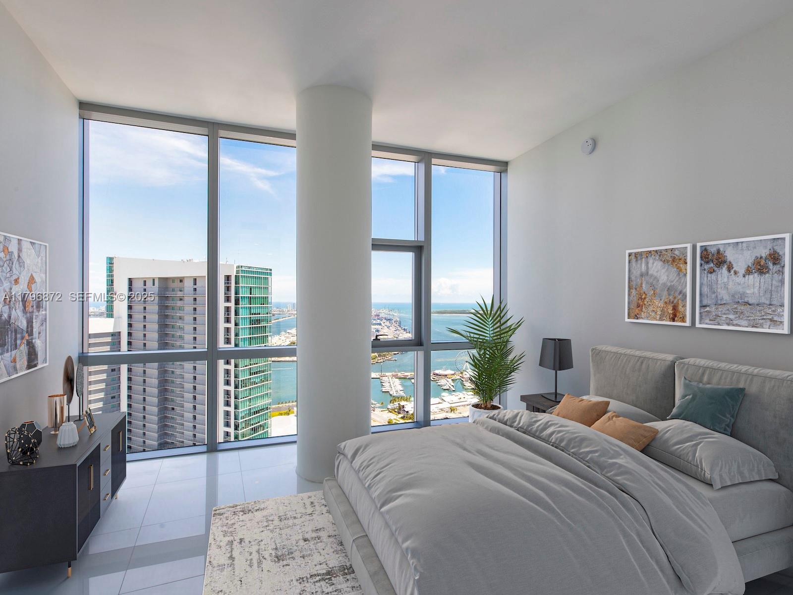 A modern bedroom features floor-to-ceiling windows with a view of a harbor and city skyline — 851 NE 1st Ave, Miami FL 33132, MIAMI, FL