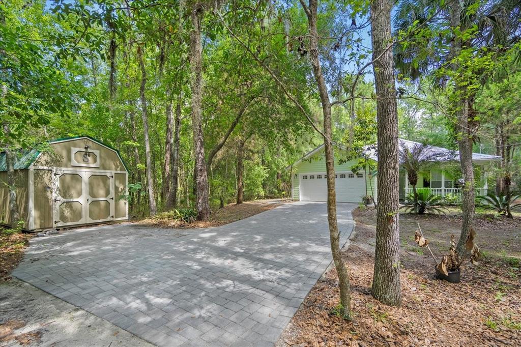 A paved driveway leads to a house with a garage and a detached storage shed — 5526 DON MANUEL ROAD, ELKTON, FL