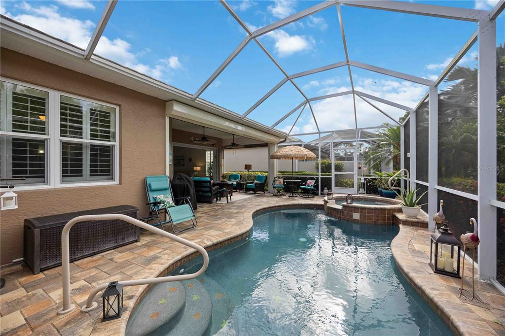A screened-in patio features a swimming pool, a raised hot tub, and outdoor seating — 11045 BARNSLEY DRIVE, VENICE, FL
