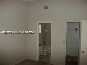 A bedroom view showing an open doorway to a bathroom and a closet door — 1318 White Pine Dr, Wellington FL 33414, WELLINGTON, FL