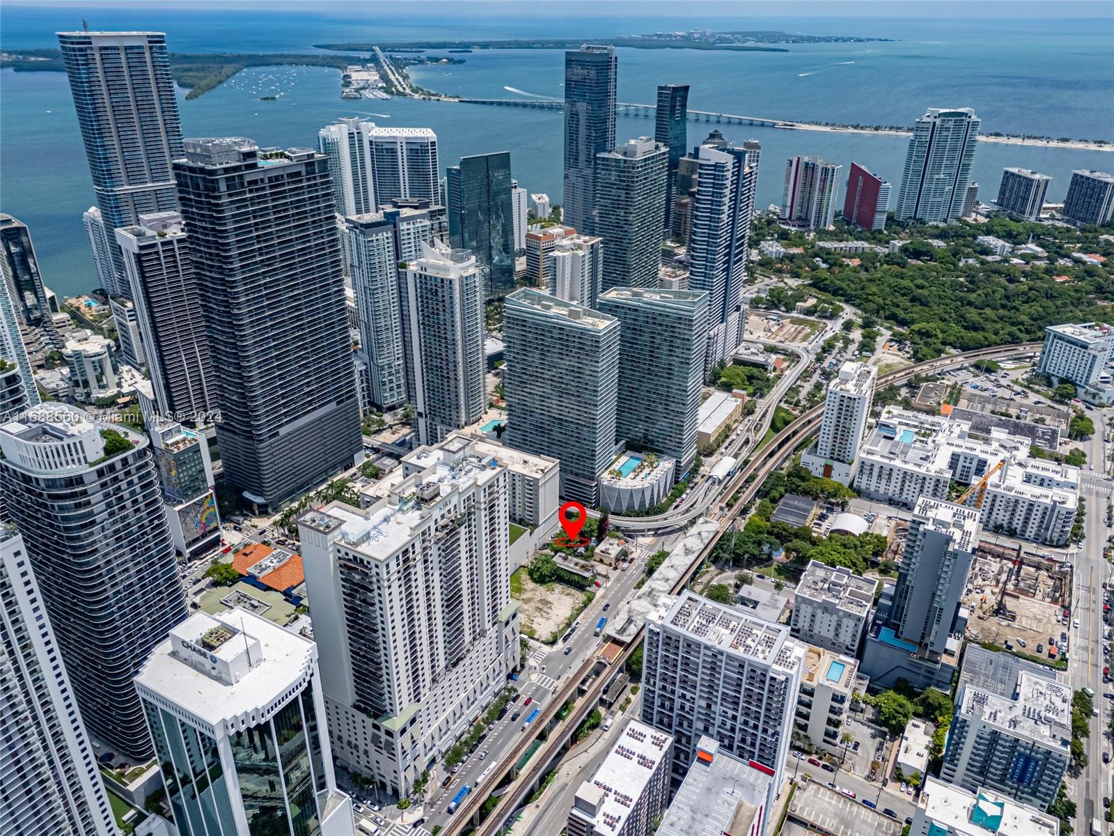 Aerial view of a dense urban cityscape with a red pin marking a small lot — 75 SW 11th St, Miami FL 33130, MIAMI, FL