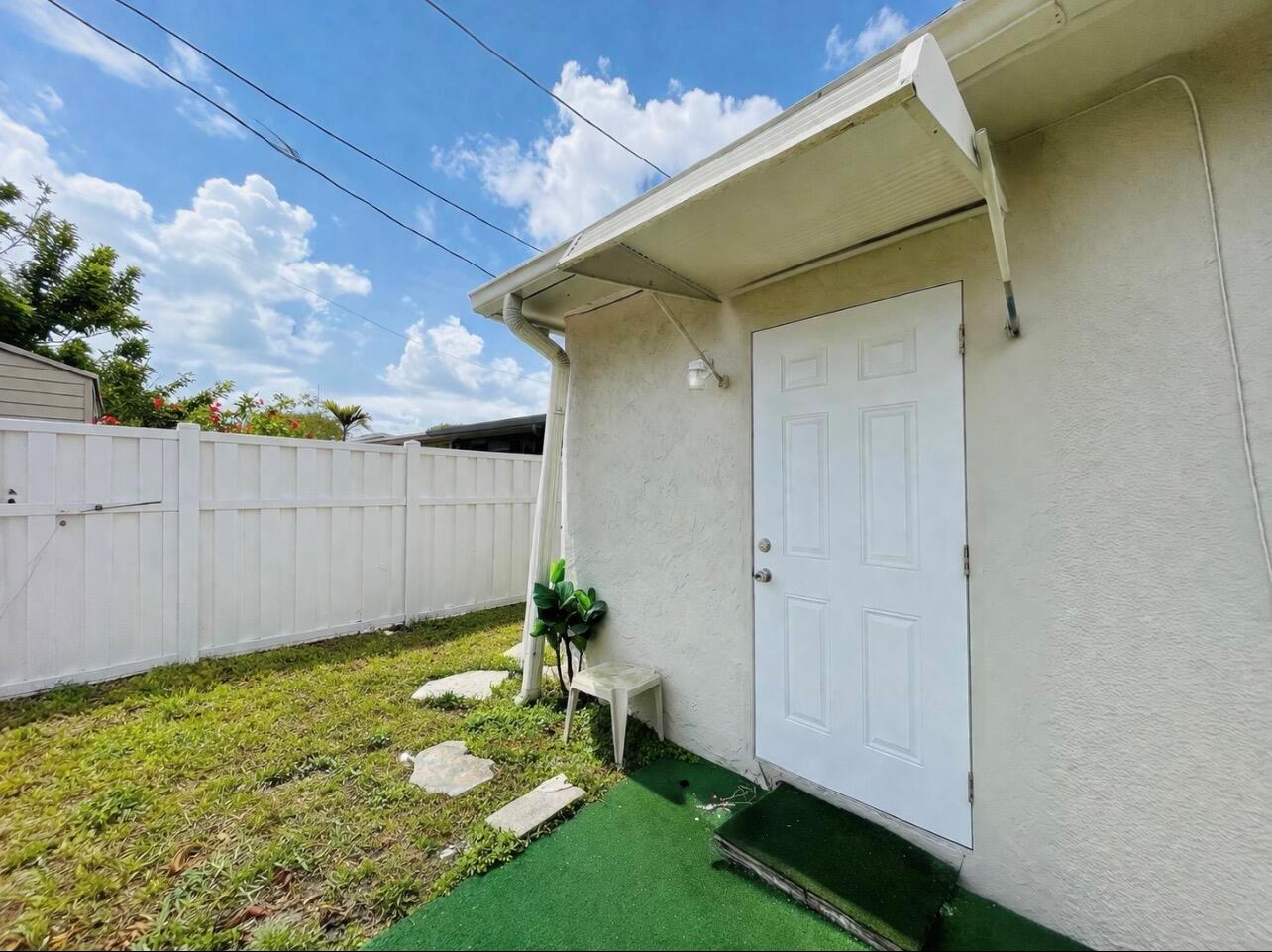 A white exterior door with an awning sits beside a small patch of artificial turf — 11361 NW 32nd Place, Sunrise FL 33323, SUNRISE, FL