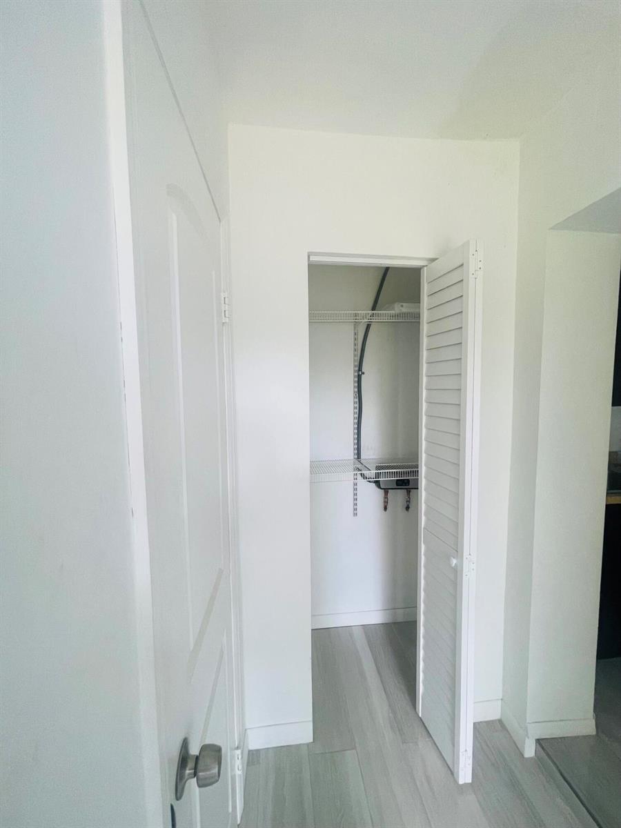 A hallway features a white door on the left and an open closet with shelving — 11361 NW 32nd Place, Sunrise FL 33323, SUNRISE, FL