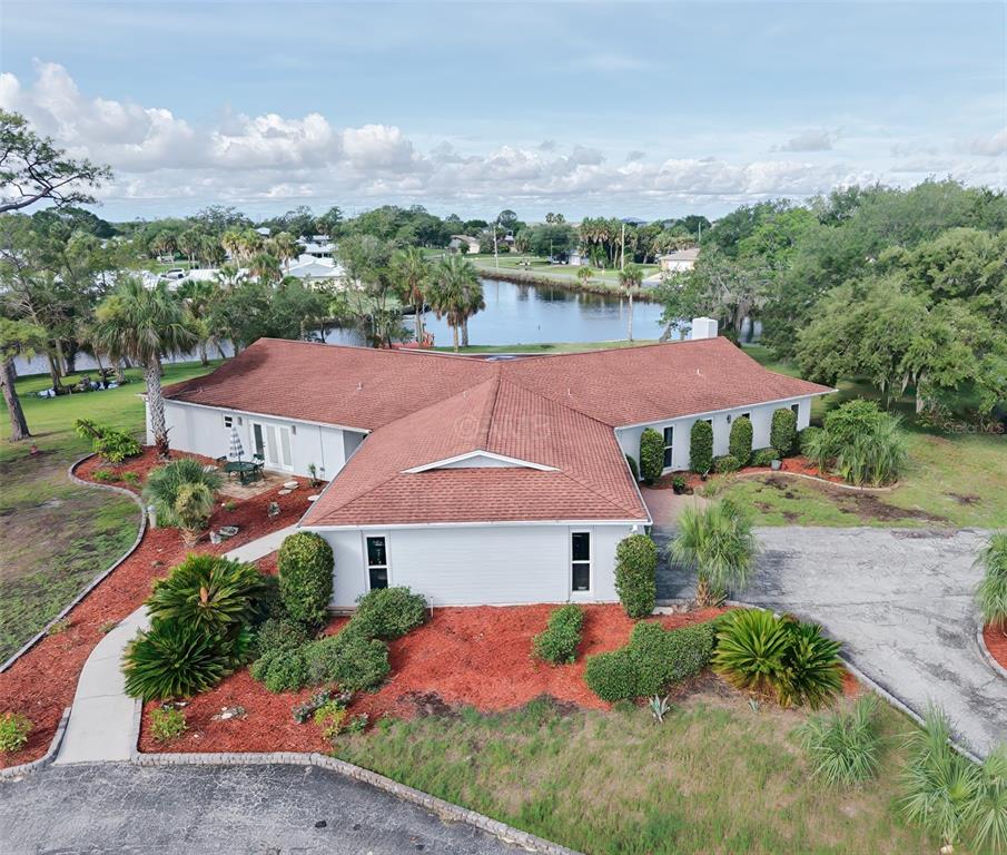 An entryway features tan tile flooring, a modern chandelier, and glass-paneled double doors with sidelights — 11580 W DIXIE SHORES DRIVE, CRYSTAL RIVER, FL