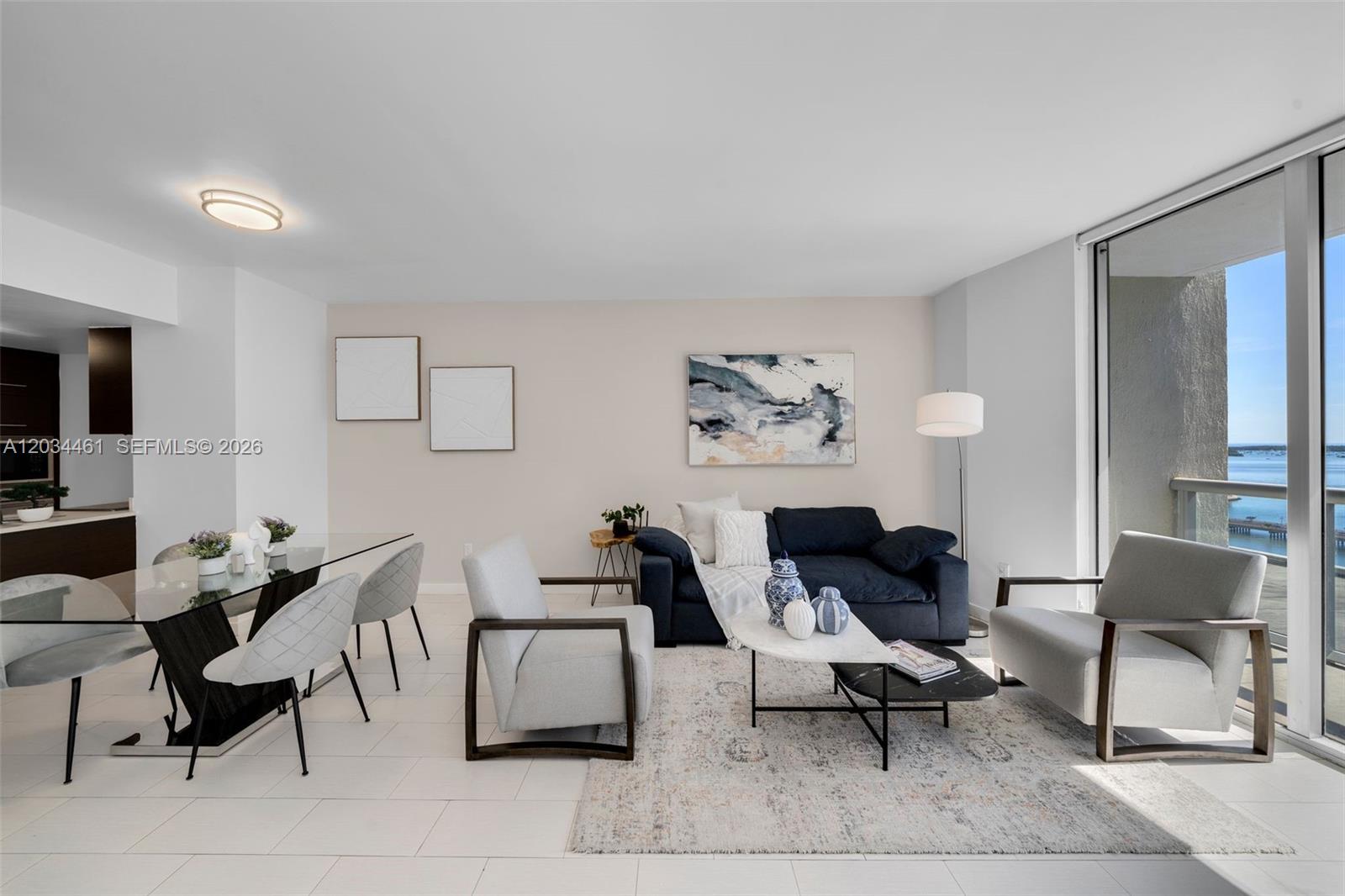 A living and dining area features a navy sofa, light armchairs, and a glass table — 485 Brickell Ave # 1709, Miami FL 33131, MIAMI, FL