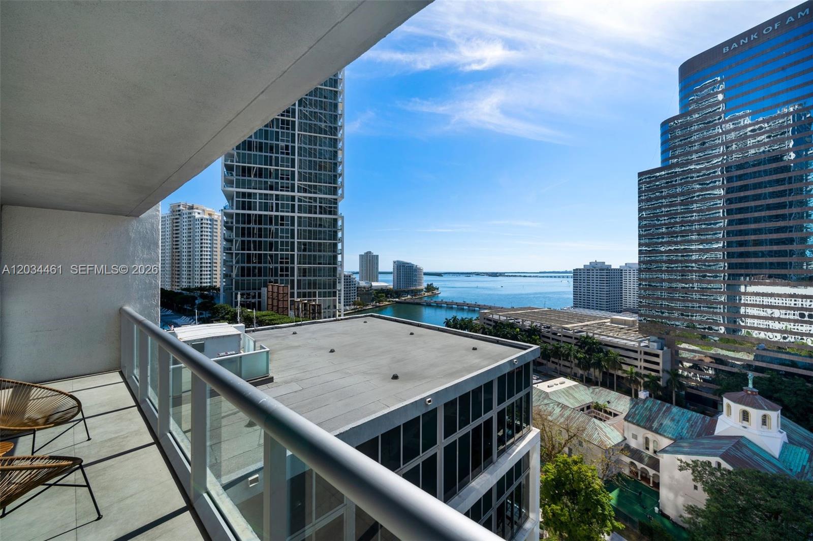 A balcony view overlooks a city skyline, a body of water, and nearby high-rise buildings — 485 Brickell Ave # 1709, Miami FL 33131, MIAMI, FL