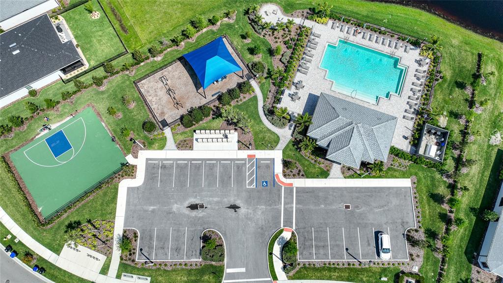 An aerial view shows a community recreation area with a pool, playground, and basketball court — 2117 LAURIFOLIA COURT, NORTH PORT, FL