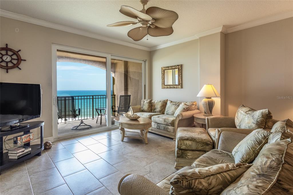 A living room with tile floors, a ceiling fan, and a balcony overlooking the ocean — 60 SURFVIEW DRIVE UNIT 804, PALM COAST, FL