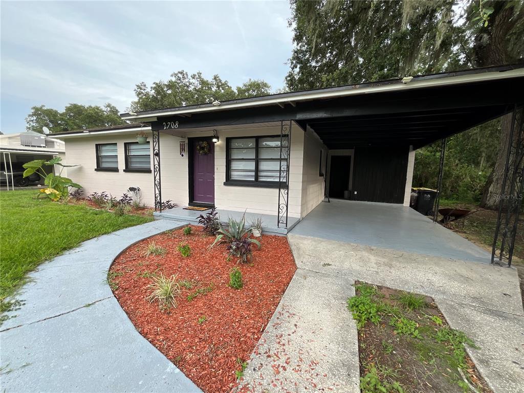 A single-story house with a purple front door, black trim, and a covered carport — 2708 DIXIE ROAD, LAKELAND, FL