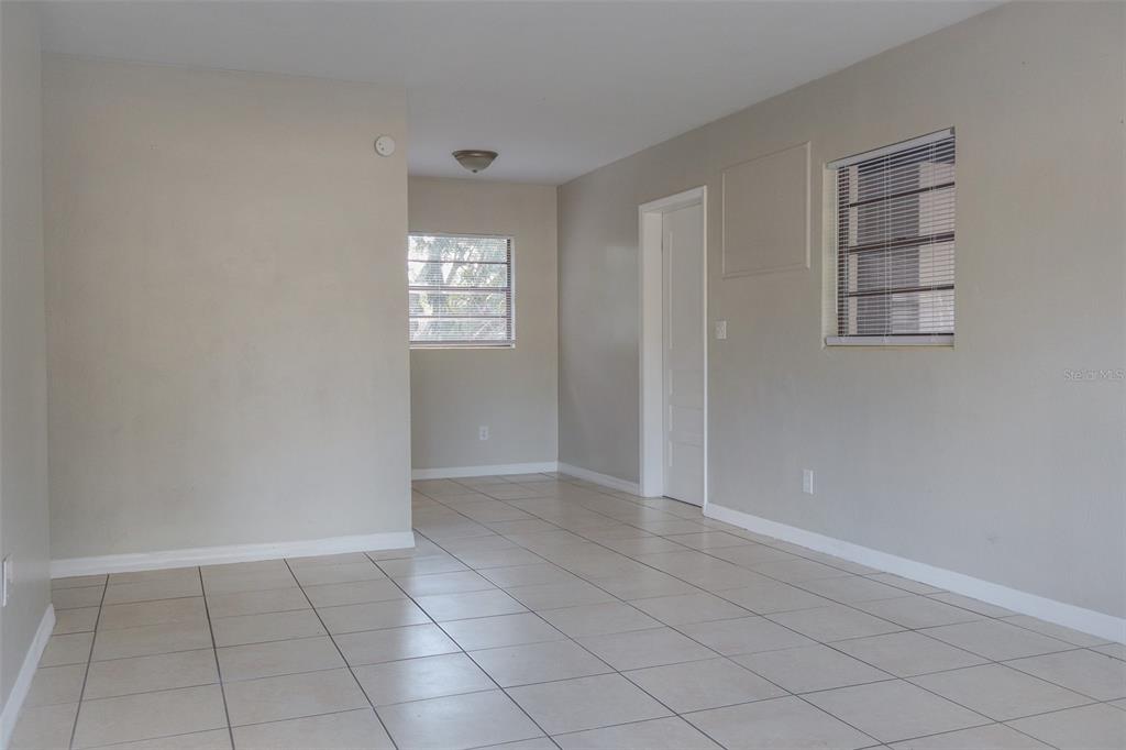 An empty room features beige walls, light-colored floor tiles, and two windows with blinds — 2708 DIXIE ROAD, LAKELAND, FL