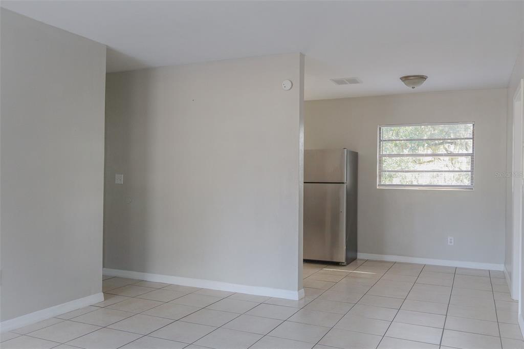 A kitchen area with light tile flooring, a stainless steel refrigerator, and a window — 2708 DIXIE ROAD, LAKELAND, FL