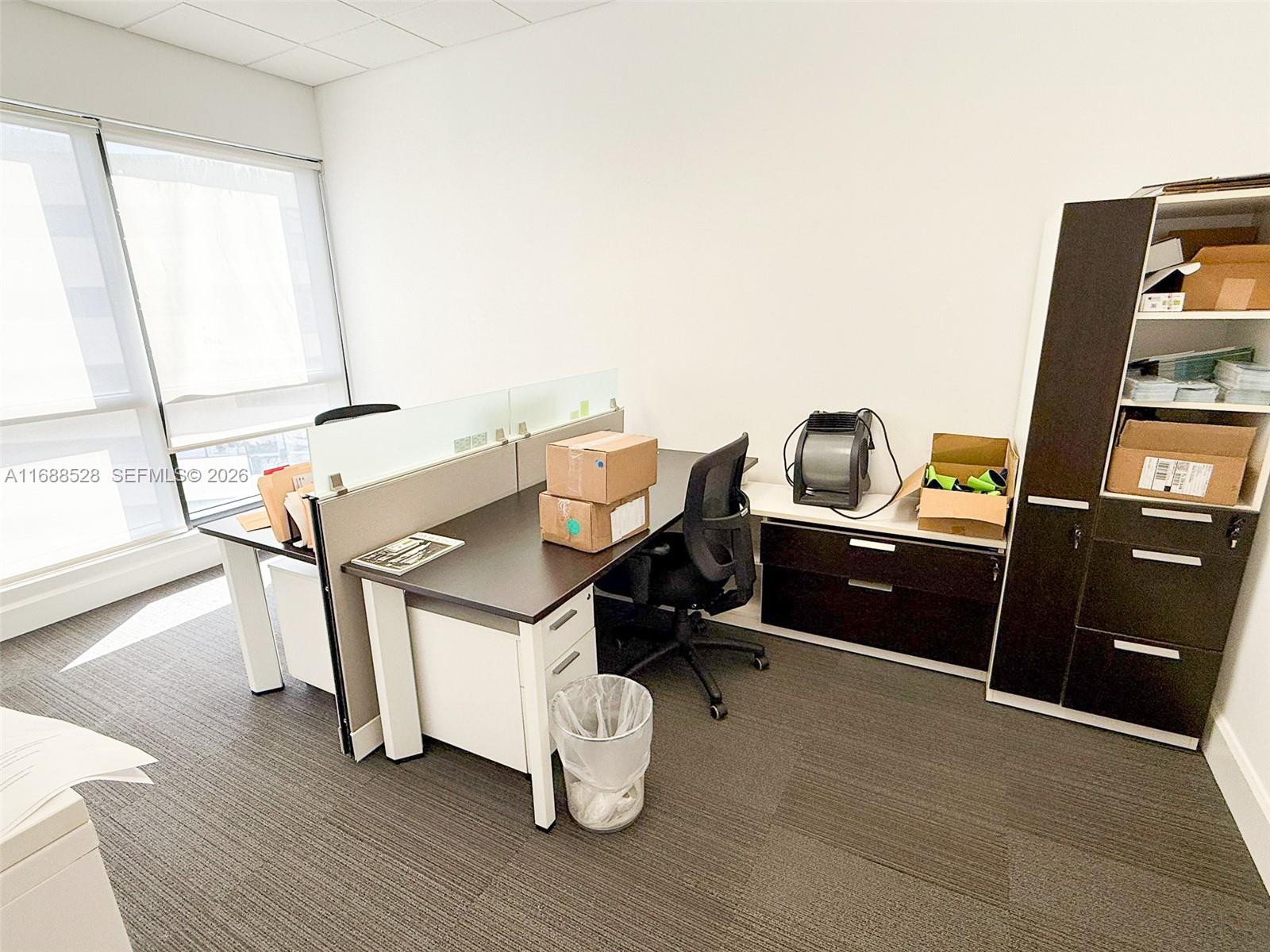 An office space features a desk, a rolling chair, storage cabinets, and a window — 2020 Ponce De Leon Blvd, Coral Gables FL 33134, CORAL GABLES, FL