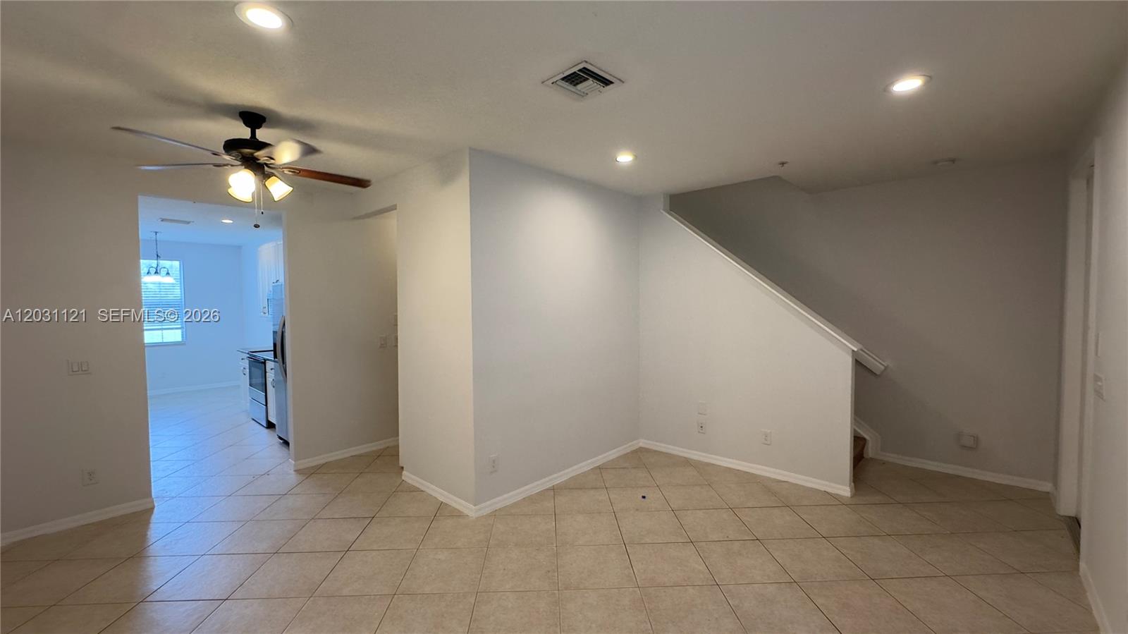 An interior view shows a tiled living area with a ceiling fan and staircase — 1587 Frederick Small Rd, Jupiter FL 33458, JUPITER, FL
