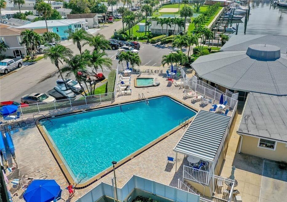 An aerial view shows a rectangular swimming pool, a hot tub, and a covered patio area — 10701 S Ocean Drive, Jensen Beach FL 34957, JENSEN BEACH, FL