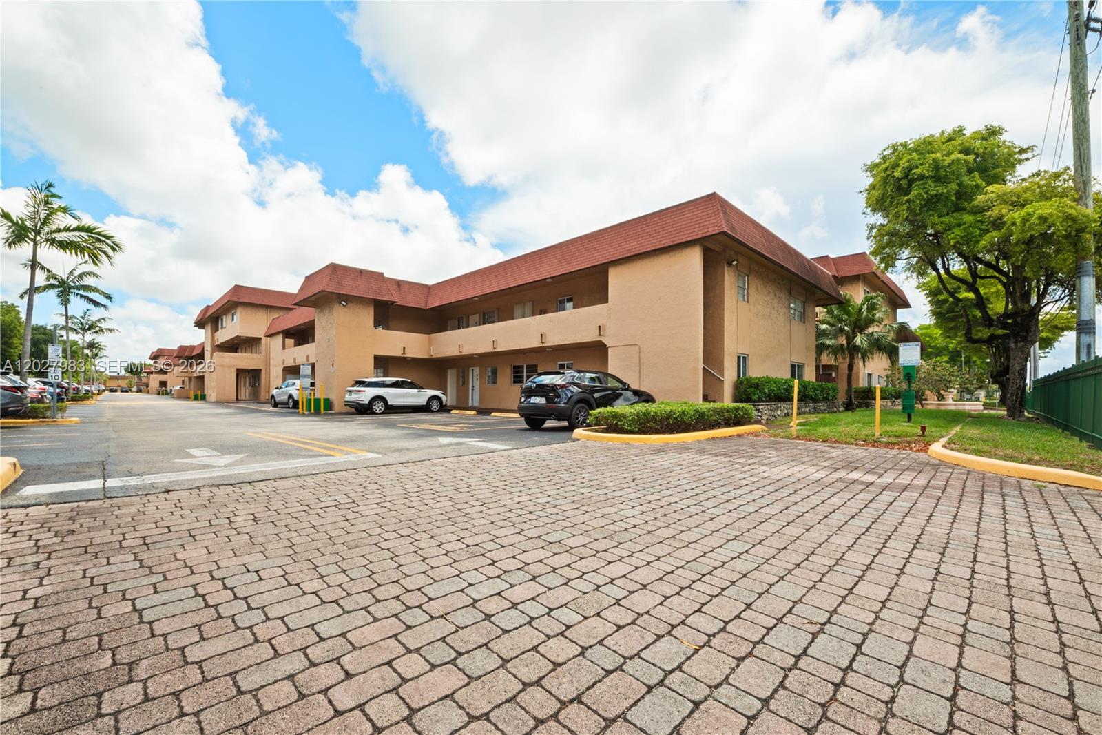 A two-story tan apartment building with a red roof and a paved parking lot — 9950 SW 88th St # 4, Miami FL 33176, MIAMI, FL