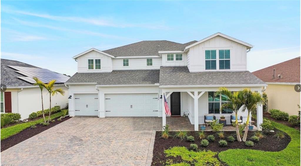 A two-story white house with a paved driveway, a three-car garage, and a front porch — 15776 APPALACHIAN DRIVE, PUNTA GORDA, FL