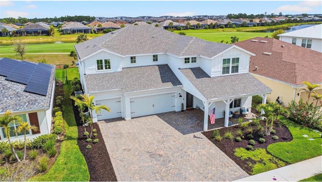 An aerial view of a two-story white house with a paved driveway and shingled roof — 15776 APPALACHIAN DRIVE, PUNTA GORDA, FL