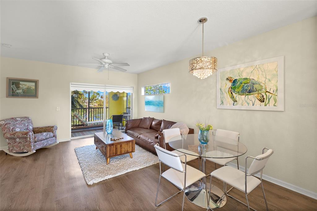 A living and dining area features a brown leather sofa, glass table, and balcony view — 2060 WILLOW HAMMOCK CIRCLE UNIT D304, PUNTA GORDA, FL