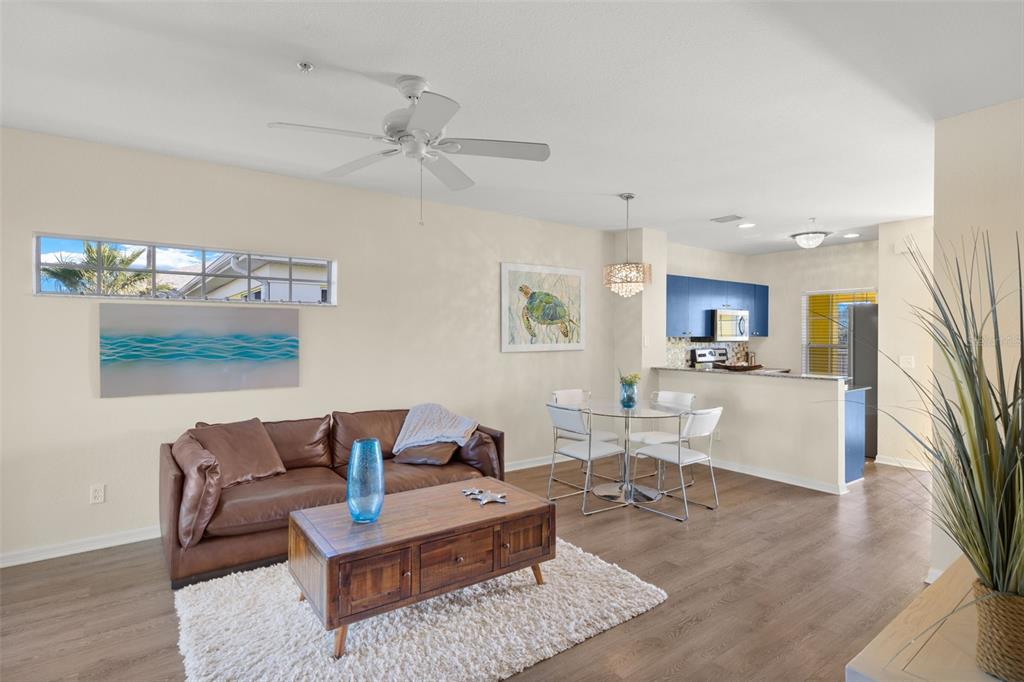 A living room with a brown leather sofa, coffee table, and dining area near a kitchen — 2060 WILLOW HAMMOCK CIRCLE UNIT D304, PUNTA GORDA, FL