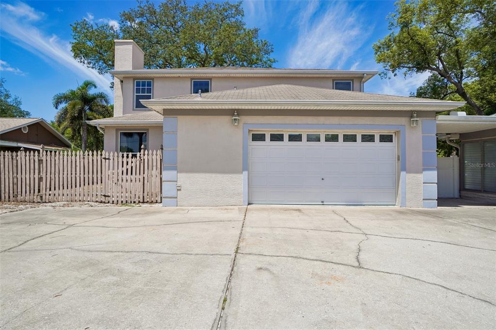 A two-story house with a white garage door and a concrete driveway — 3220 COUNTY ROAD 1, DUNEDIN, FL