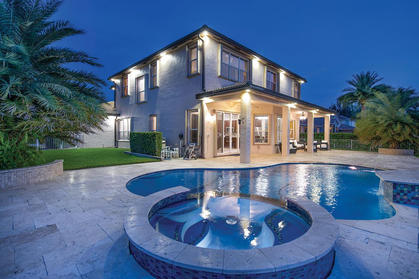 A two-story house with a backyard pool, spa, and covered patio at twilight — 5422 SW 185th Terrace, Miramar FL 33029, MIRAMAR, FL