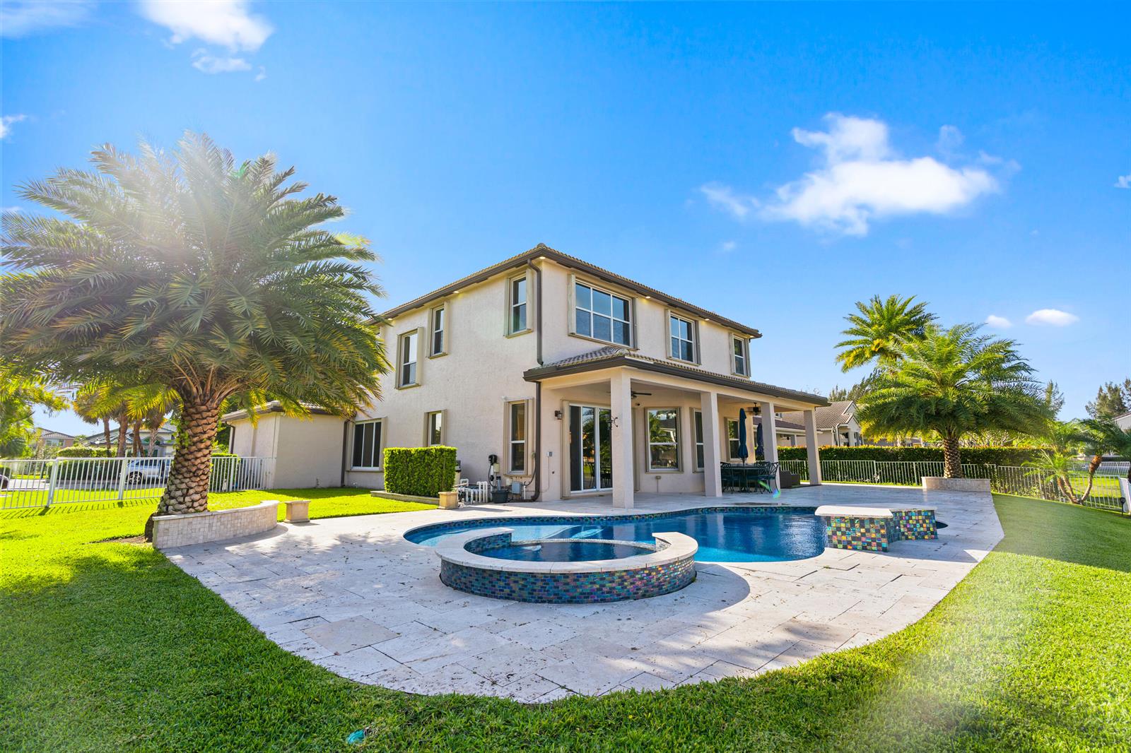 A two-story house with a backyard pool, hot tub, and palm trees under a blue sky — 5422 SW 185th Terrace, Miramar FL 33029, MIRAMAR, FL