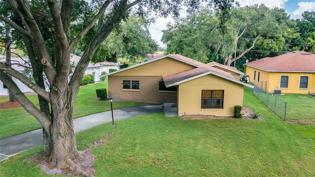 An exterior view of a single-story house with a tan facade and a paved driveway — 209 BAYSHORE DRIVE, ORLANDO, FL