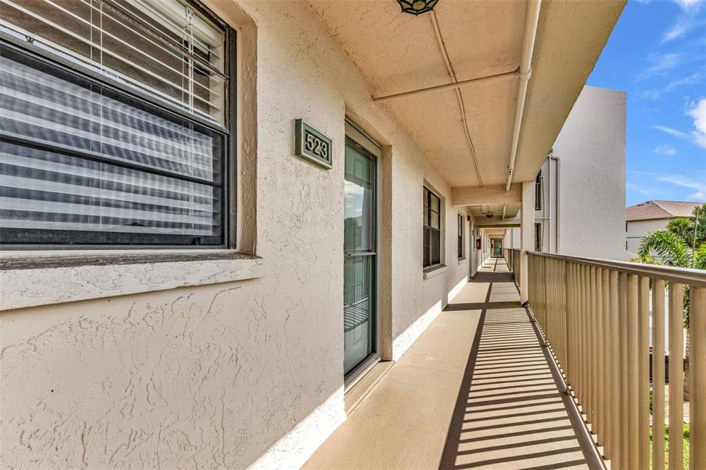 An exterior view of an apartment building walkway with unit number 523 — 175 KINGS HIGHWAY UNIT 523, PUNTA GORDA, FL