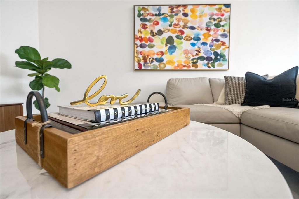 A wooden tray with books and a gold love sign sits on a marble table — 2 Condado Princess WASHINGTON UNIT 103, SAN JUAN, PR