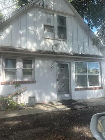 The exterior of a white, two-story house features a front door and several windows — 3835 8TH STREET S, ST PETERSBURG, FL