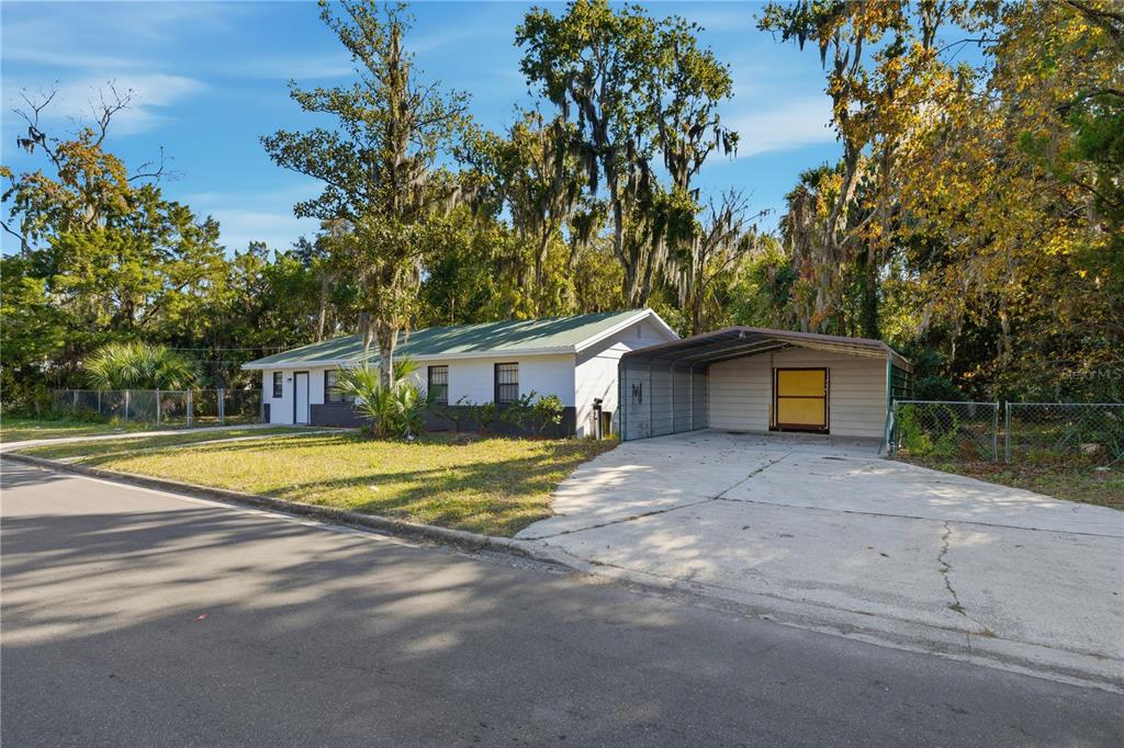 A single-story house with a green metal roof and an attached metal carport — 1915 BRONSON STREET, PALATKA, FL